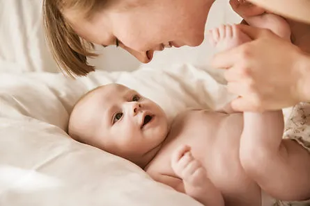Mutter, die mit neugeborenem Baby lächel